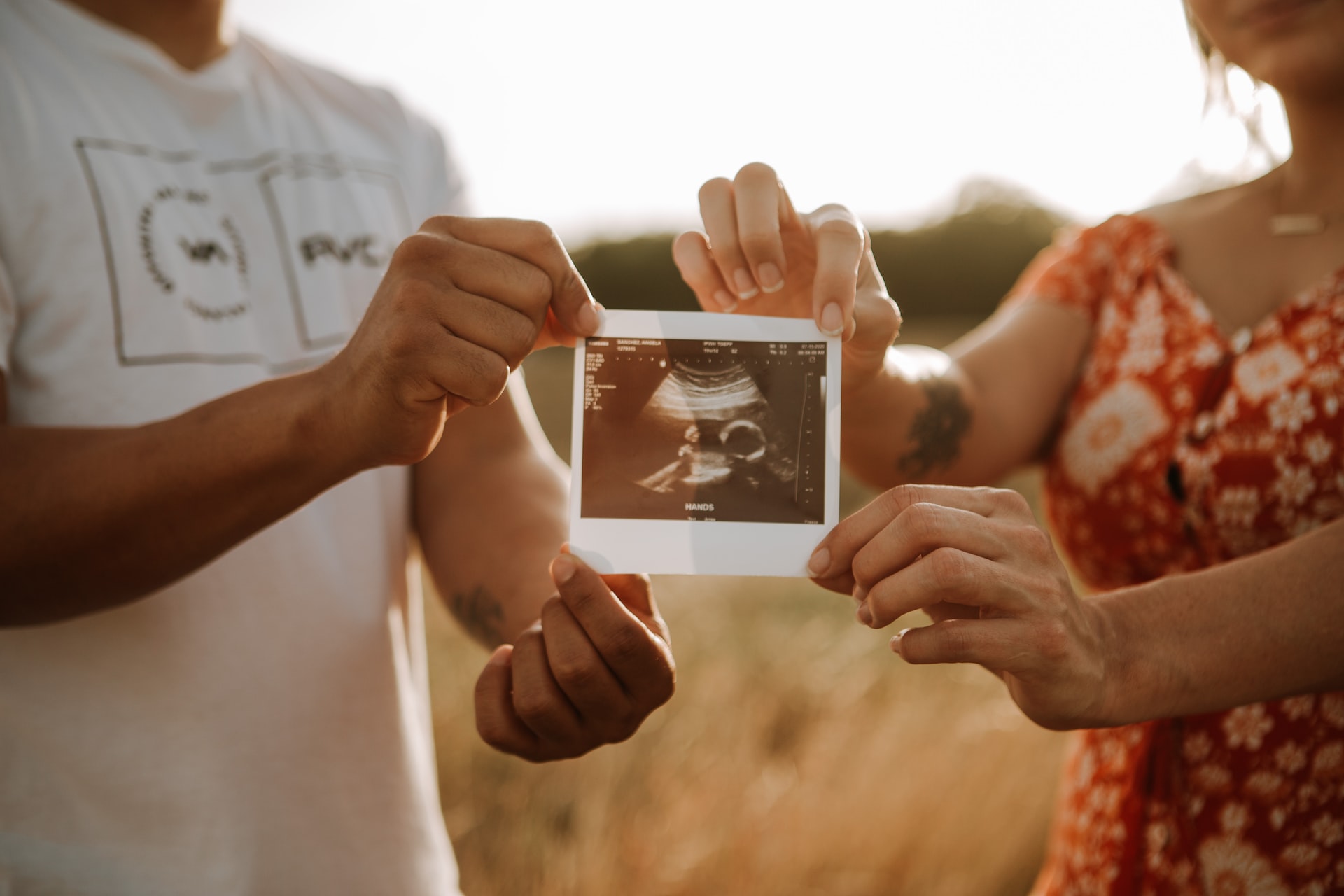 mamá y papá mostrando foto de ecografía bebé